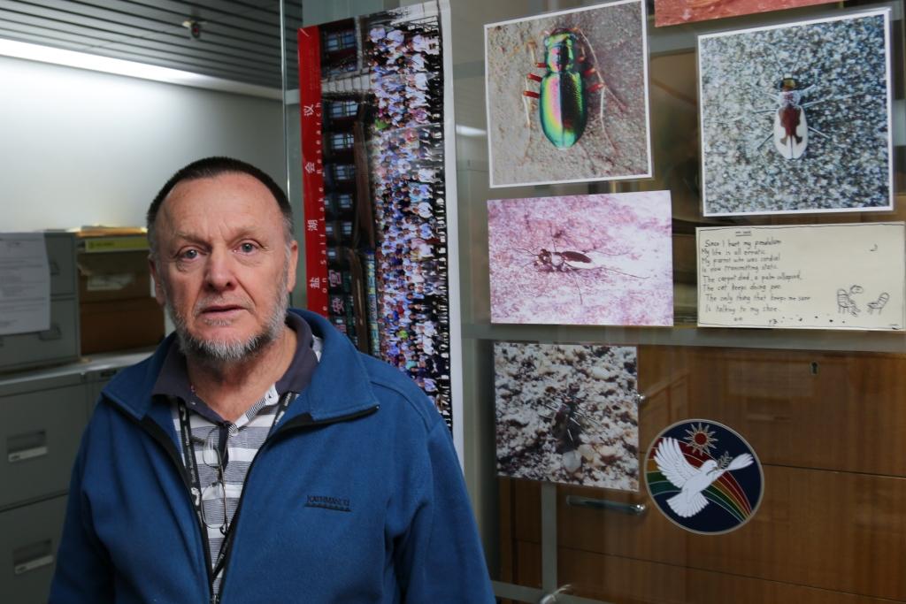 Peter Hudson and his office door, featuring photos of Tiger Beetles and other salt lake invertebrates.