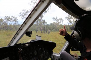 Flying in the wet season: helicopter pilot Mitch Ballantyne gives the thumbs up for a team to approach the chopper.