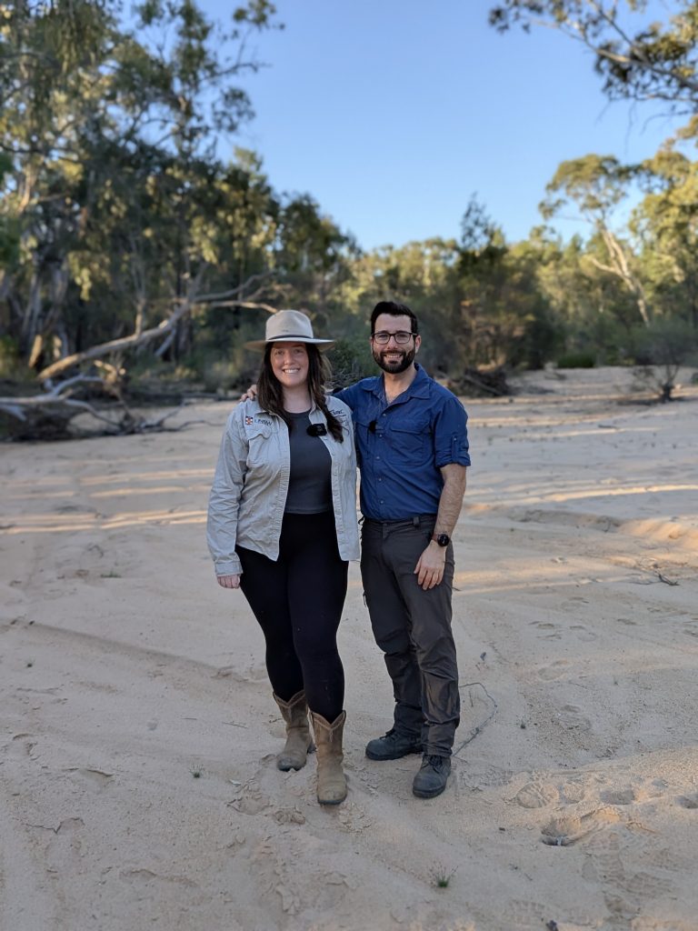 Maya Darby and Bryan Lessard smiling in a sandy creek